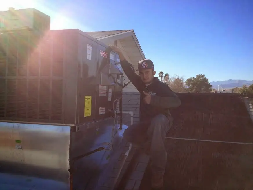 HVAC technician performing Heat Pump Repair on a rooftop unit in Columbus